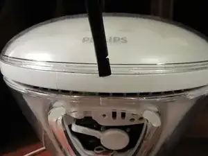 Flipping the light on its back will present a small section of the bezel that can be pried out. It is a small plastic strip with hooks that have to be disengaged to be removed.