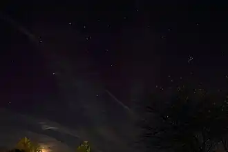 photograph of night sky above a dimly-lit horizon