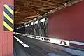 A picture showing the inside of the covered bridge from an angle to show decking and road bed