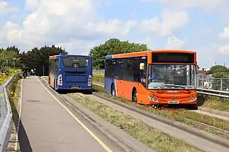 Buses pass on the Busway alongside a pedestrian path