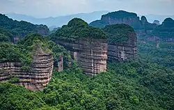 A series of stone pillars, partially covered with vegetation