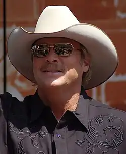 A head shot of Alan Jackson, wearing a cowboy hat and sunglasses