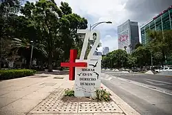 A monument that reads as Plus 72. It also has written in Spanish the phrase "Migration is a human right" (Migrating is a human right).