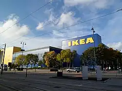 A blue building with "Ikea" written on the side in large yellow letters. Trees in the foreground.