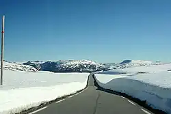 Bare road snow on both sides across a plateau