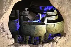 a cave with many bronze vessels