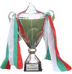 A silver trophy in a typical cup shape decked with red, white and green ribbons
