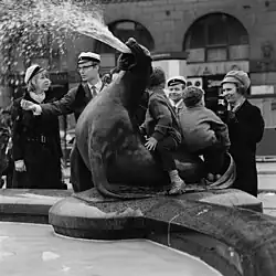 Children playing on a sea lion and a man throwing a coin, 1968