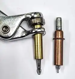 A Cleco fastener, extended, with a retracted fastener.