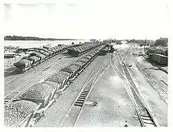 Loaded rail coal trucks, rail tracks and the river on the left