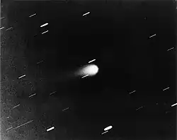 Gray scale photograph of Kohoutek, appearing as a bright, teardrop-shaped object at center with a faint tail