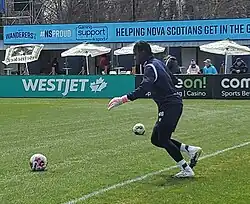 Darlington Murasiranwa is running and preparing to kick a ball