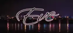 The word Eve is written in black cursive font and is presented against a nighttime panoramic image of downtown Miami.