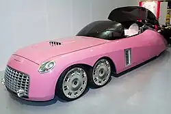 A six-wheeled car with tinted glass canopy, in a car museum