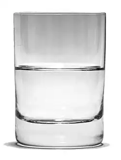 a glass of transparent water sitting on a wooden table