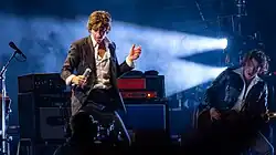 Alex Turner and Nick O'Malley on a stage performing