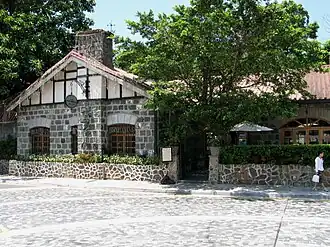 Single storey stone building with chimney and gabled tiled roof