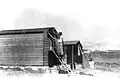 Weatherproofing being fixed to the exterior of first cabins at Harel. 27 October 1948.