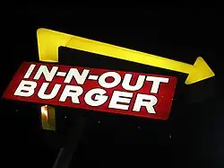 Classic red and white In-N-Out Burger sign with palm trees