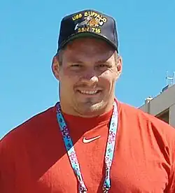 Jeff Hartings from the shoulders up in an orange shirt and a hat that says "USS BUFFALO SSN-715".