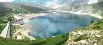 A body of water surrounded by green grass.