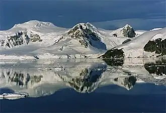 Glaciers and cliffs reflected in still waters at the south end of the channel