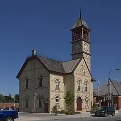 Exterior photo of two-story building with a bell tower
