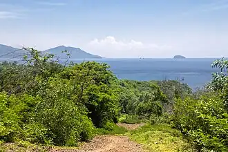 View east from the hill on the western side of the port: Candidasa over the wider bay, and the rock of Gili Bia[25] jutting out in the Lombok Strait