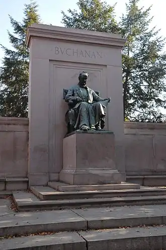 Statue of a seated man surrounded by large stonework
