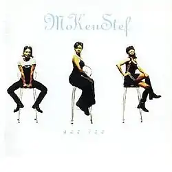 The cover consists of three women sitting on stools against a white background.
