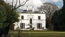 A south-side view of Mulberry House, the former rectory. A horse which belongs to the grounds is shown directly to the left