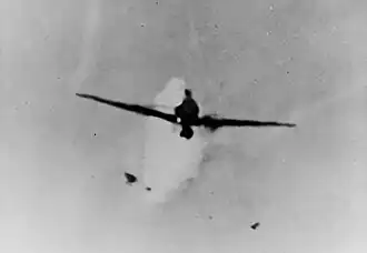 The Mitsubishi A6M Zero kamikaze moments before it struck Columbia's antennae on 6 January. Note fragments of the plane falling off as the ship's anti-aircraft guns attempted to shoot it down
