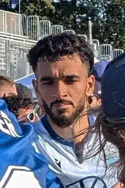 Player with a stern look seen between fans after a match