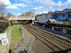 A railway station with two low-level side platforms in an open cut