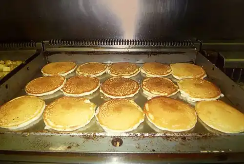 Pancakes cooking on a commercial griddle