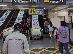 Passengers standing on the right side in Taiwan, despite the "Stand on either side" sign