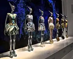 Several mannequins in a row, each wearing a different dress and shoes