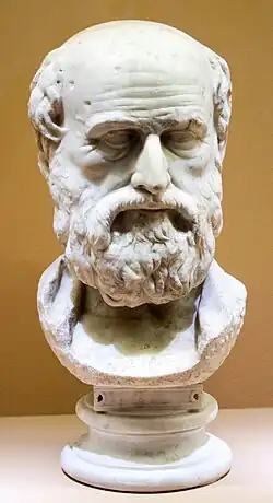 Marble head of an older man, mostly bald, with a full beard.