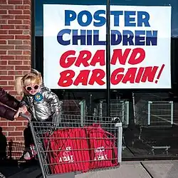 A mock-up grocery store with a sign that reads "GREAT BARGAIN" and a little girl in a cart being pushed in front of it