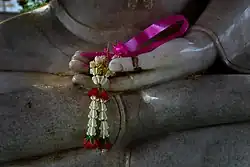 Flower offered in the hand of a Buddha image