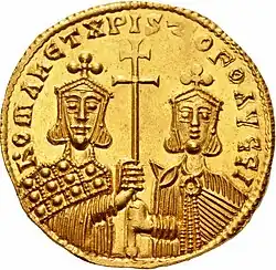Gold coin depicting two men (Romanos I Lekapenos on the left and Christopher on the right) with diadems, both of whom are holding a singular patriarchal cross. The figures are encircled by text.