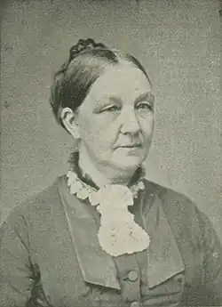 B&W portrait photo of a middle-aged woman with her hair in an up-do