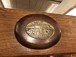 Plaque inside the cabin, commemorating her build. Reads 'Designed and built by Short Bros (Rochester Ltd.) Rochester' Is gold in color and the lettering is worn, showing its age.