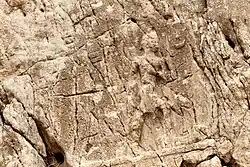 Sarpol-e Zahab, relief I. Beardless warrior with axe, trampling a foe. Sundisk above. A name "Zaba(zuna), son of ..." can be read. He is usually considered as a ruler of the Lullubi,[63][64] but he could be a ruler of the Kingdom of Simurrum, son of Iddin-Sin.[10]