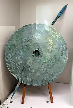 Round shield decorated with concentric bands in relief with horses and circles, bronze, Necropolis of the Four Fountains, shaft tomb AA1, 750 BC.