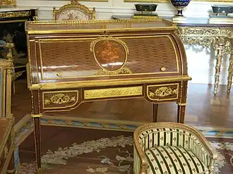 Roll-top desk of Marie-Antoinette; by Jean-Henri Riesener; 1784; oak and pine frame, sycamore, amaranth and rosewood veneer, bronze gilt; 103.6 x 113.4 cm; Louvre[71]