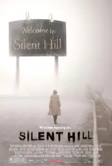 A woman walks in a foggy road; in front of her is a sign that reads "Welcome to Silent Hill".