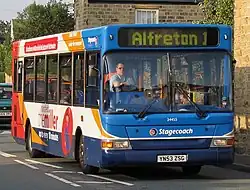 Cropped image to show a close up of front and side of single decker coach size bus on a road facing camera position