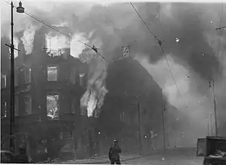 NARA copy #27, IPN copy #23 Destruction of a housing block Zamenhofa Street looking North, with burning Zamenhofa 25 / Wołyńska 2 on the left.