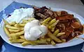 A "Taxi Teller" is a plate of fries served with currywurst, shashlik sauce, mayonnaise, gyros meat, and tzatziki.